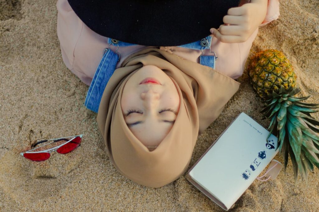Woman Lying on Sand Beside Sunglasses