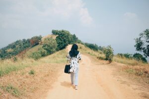Back View Photo Woman in Black Hijab Walking Alone on Dirt Road
